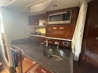 Hanky Panky Yacht Photos Pics Interior kitchen of 2012 Sea Ray 350 Sundancer with sink, microwave, and storage cabinets.