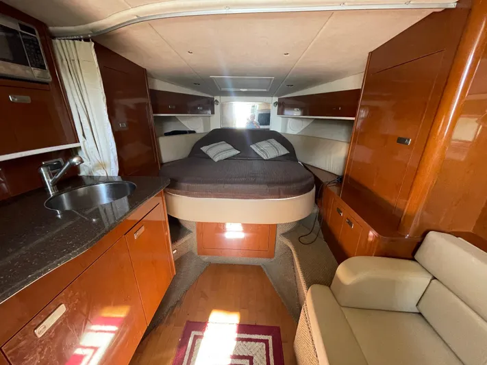 Hanky Panky Yacht Photos Pics Interior of 2012 Sea Ray 350 Sundancer yacht with bed, kitchenette, and seating area.