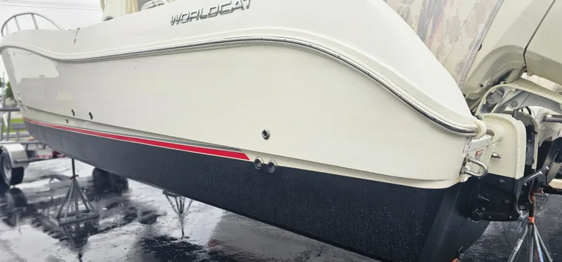  Yacht Photos Pics 2016 World Cat 320 boat on trailer, white hull with red stripe, outboard motor visible.