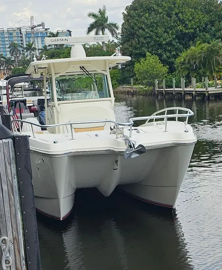  Yacht Photos Pics 2016 World Cat 320 boat docked on a calm waterway with lush greenery.