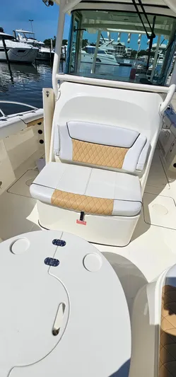  Yacht Photos Pics 2016 World Cat 320 boat interior with cushioned seating and table, docked at marina.