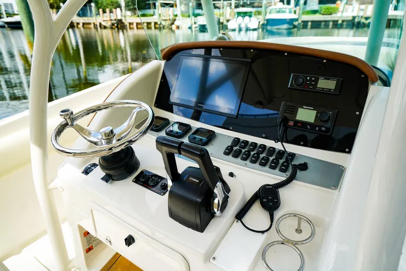 Tender Offer Yacht Photos Pics 2008 Chris-Craft Catalina 29 helm with steering wheel and control panel by the water.