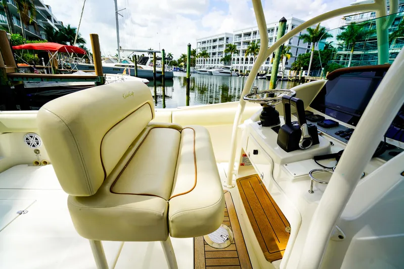 Tender Offer Yacht Photos Pics 2008 Chris-Craft Catalina 29 boat interior with beige seating and control panel at marina.