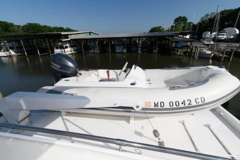  Yacht Photos Pics 1988 Hatteras 54 Motor Yacht with dinghy on deck, docked at marina.
