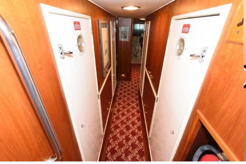  Yacht Photos Pics Interior hallway of 1988 Hatteras 54 Motor Yacht with wood paneling and patterned carpet.
