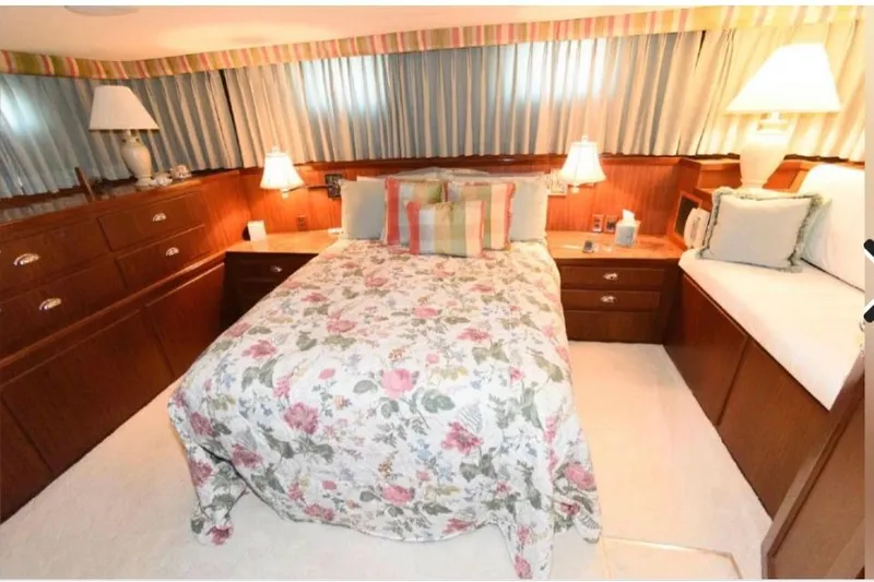  Yacht Photos Pics Bedroom interior of 1988 Hatteras 54 Motor Yacht with floral bedding and wooden furnishings.