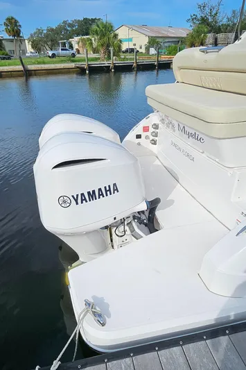  Yacht Photos Pics 2018 Regal 33 XO boat with Yamaha outboard engine docked by the water.