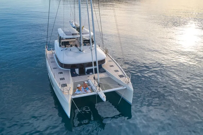 Amada Mia Yacht Photos Pics 2021 Lagoon Sixty5 catamaran sailing on calm waters at sunset.