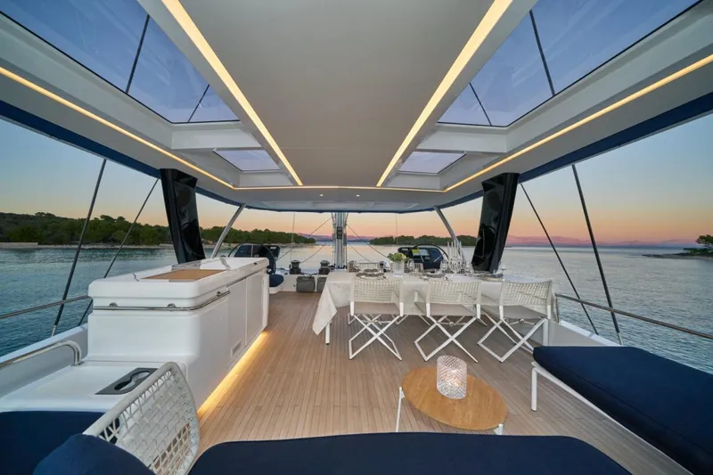 Amada Mia Yacht Photos Pics Luxurious 2021 Lagoon Sixty5 yacht interior with elegant dining area and scenic ocean view.