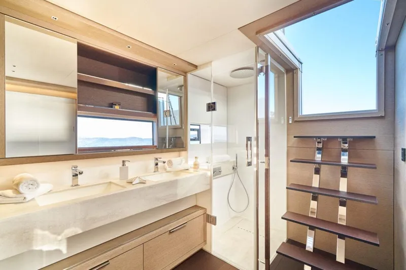 Amada Mia Yacht Photos Pics Luxurious bathroom interior of 2021 Lagoon Sixty5 yacht with modern fixtures and ocean view.