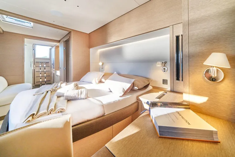 Amada Mia Yacht Photos Pics Luxurious cabin interior of 2021 Lagoon Sixty5 yacht with elegant bedding and soft lighting.