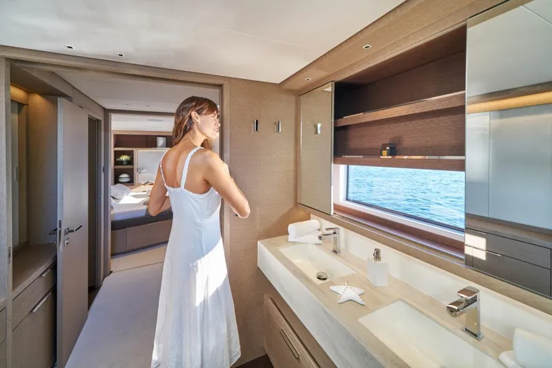 Amada Mia Yacht Photos Pics Woman in a white dress in Lagoon Sixty5 yacht bathroom, 2021 model, with ocean view.