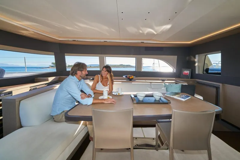 Amada Mia Yacht Photos Pics Couple enjoying a meal in the luxurious interior of a 2021 Lagoon Sixty5 yacht.