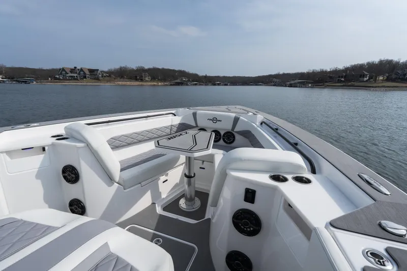  Yacht Photos Pics 2026 Fountain 38 SCX boat interior with seating and table on a calm lake.