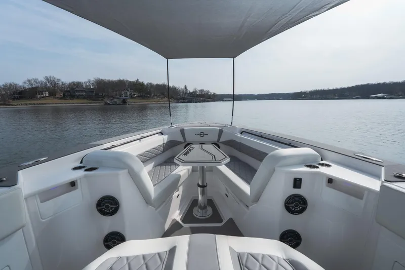  Yacht Photos Pics 2026 Fountain 38 SCX boat interior with seating and table on a calm lake.