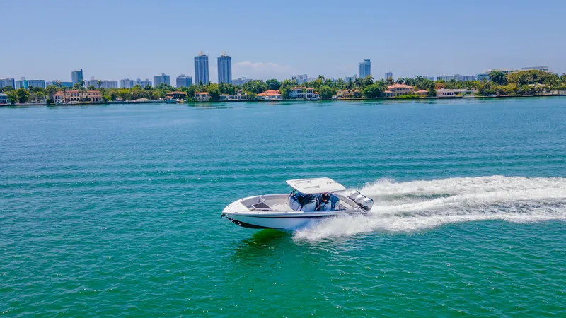  Yacht Photos Pics 2019 Nor-Tech 390 Sport boat cruising on blue water with city skyline in background.