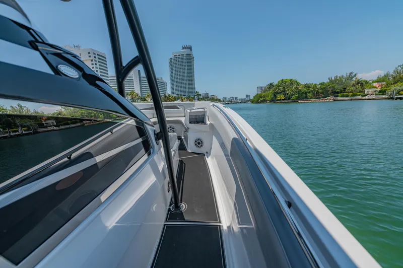  Yacht Photos Pics 2019 Nor-Tech 390 Sport boat cruising on a scenic waterway with city skyline.