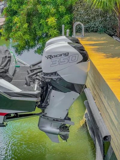  Yacht Photos Pics 2019 Nor-Tech 390 Sport boat with Racing 350 outboard engine docked by lush greenery.