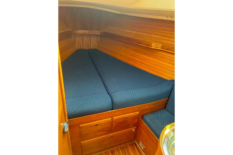  Yacht Photos Pics Cozy cabin interior of 1994 Sabre 362 sailboat with wooden paneling and blue cushions.
