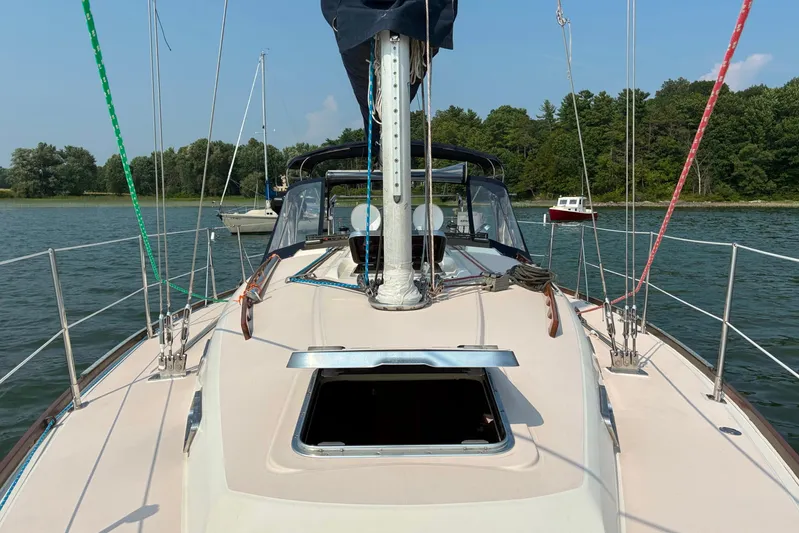  Yacht Photos Pics 1994 Sabre 362 sailboat on calm water, surrounded by lush greenery.