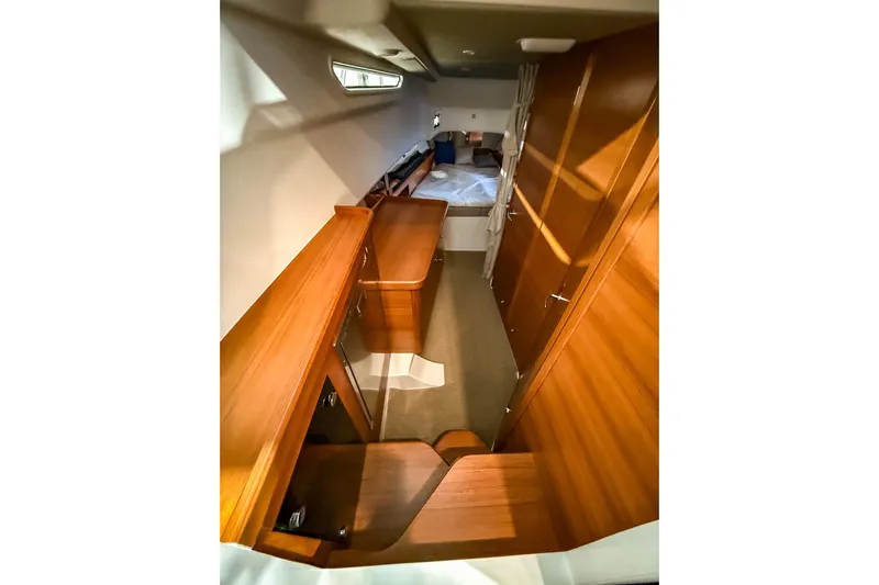  Yacht Photos Pics Interior of 2022 Nimbus T11 boat with wooden cabinetry and cozy sleeping area.