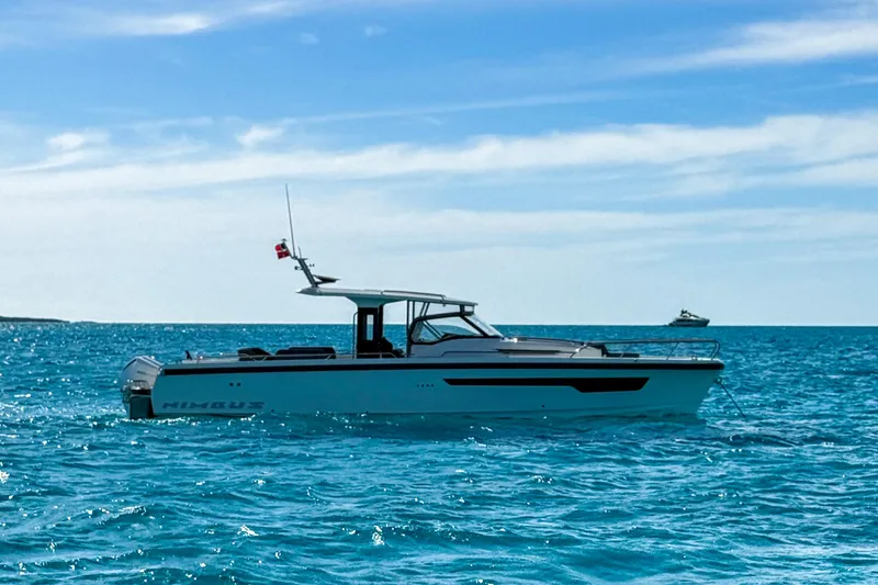  Yacht Photos Pics 2022 Nimbus T11 boat cruising on clear blue ocean under a sunny sky.