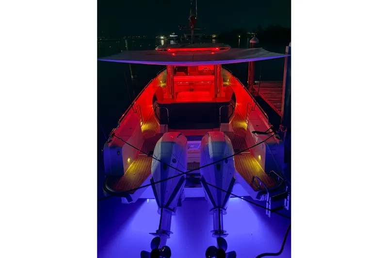  Yacht Photos Pics Nimbus T11 2022 boat illuminated with vibrant red and blue lights at night.
