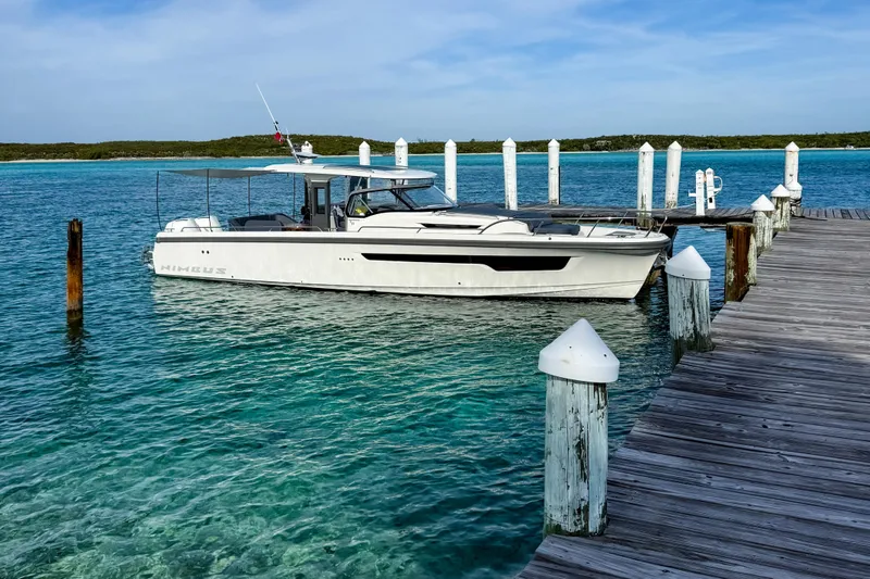  Yacht Photos Pics Nimbus T11 2022 boat docked by a wooden pier in clear turquoise water.