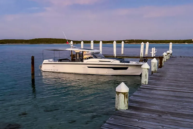  Yacht Photos Pics Nimbus T11 2022 boat docked at a serene wooden pier during sunset.
