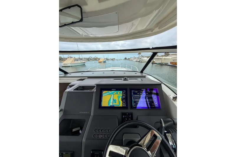  Yacht Photos Pics Interior view of 2022 Nimbus T11 boat cockpit with navigation screens and steering wheel.