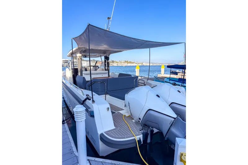  Yacht Photos Pics Nimbus T11 2022 boat docked, featuring dual engines and a shaded seating area.