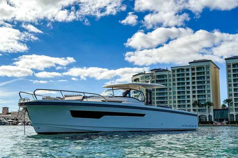  Yacht Photos Pics Nimbus T11 2022 boat on water with modern buildings in the background.