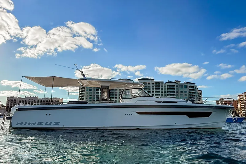  Yacht Photos Pics 2022 Nimbus T11 yacht on water, cityscape background, clear sky.