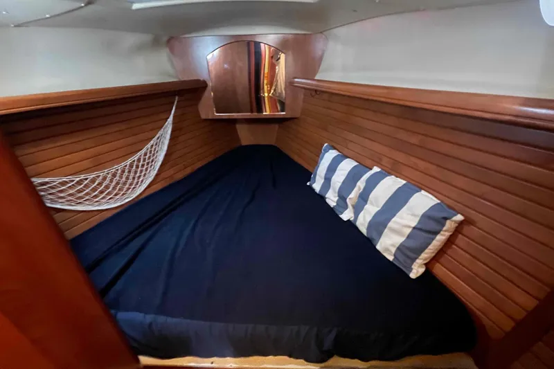 Snail'n Yacht Photos Pics Cozy cabin interior of 2010 Hunter 45 Center Cockpit with striped pillows and wood paneling.