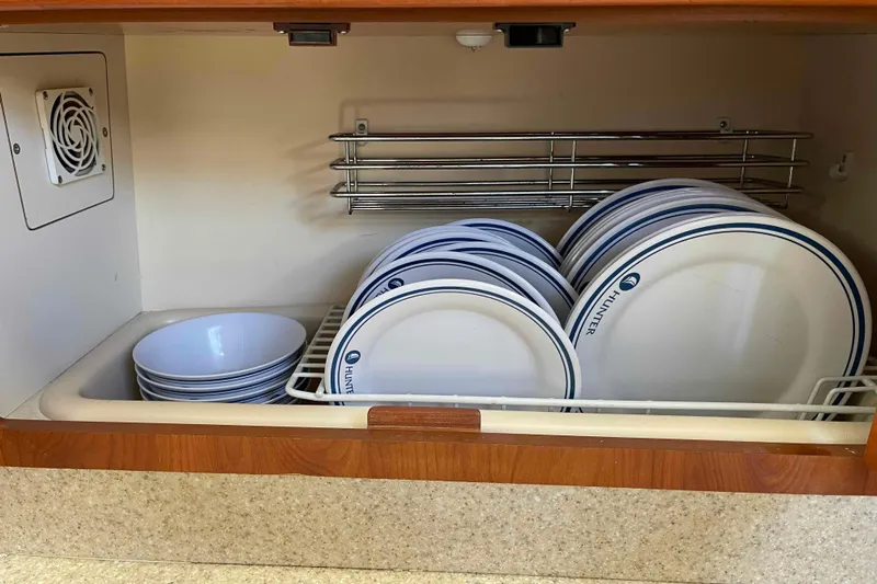 Snail'n Yacht Photos Pics Dishes neatly stored in a 2010 Hunter 45 Center Cockpit kitchen cabinet.