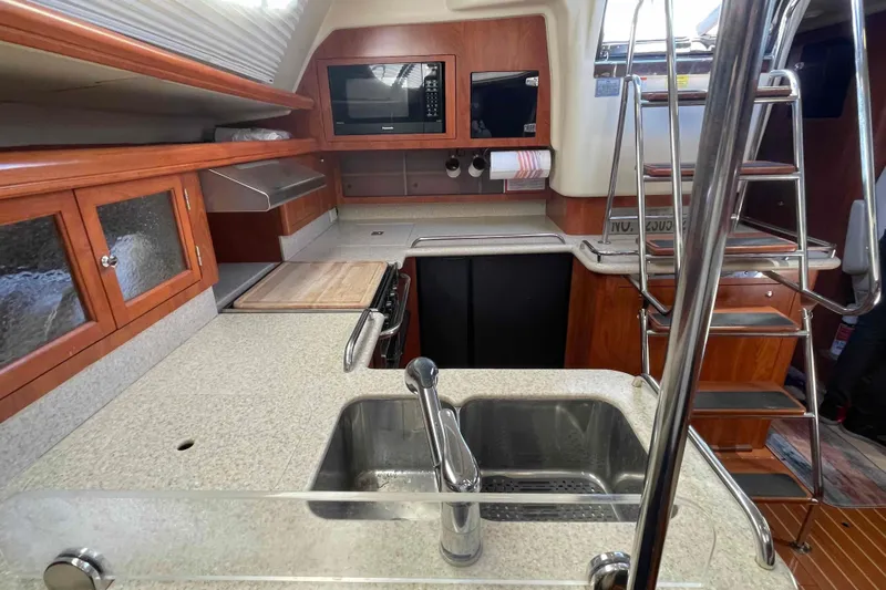 Snail'n Yacht Photos Pics Modern kitchen in 2010 Hunter 45 Center Cockpit yacht with wood cabinetry and stainless steel sink.
