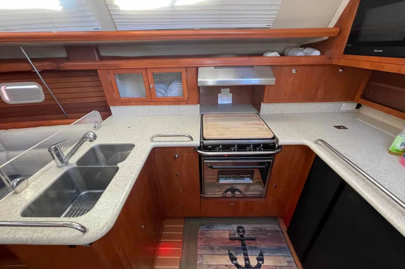 Snail'n Yacht Photos Pics 2010 Hunter 45 Center Cockpit kitchen with dual sinks, stove, and wooden cabinetry.