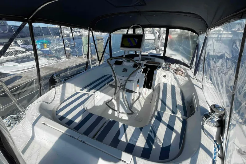 Snail'n Yacht Photos Pics 2010 Hunter 45 Center Cockpit with striped seating and navigation equipment, docked at marina.