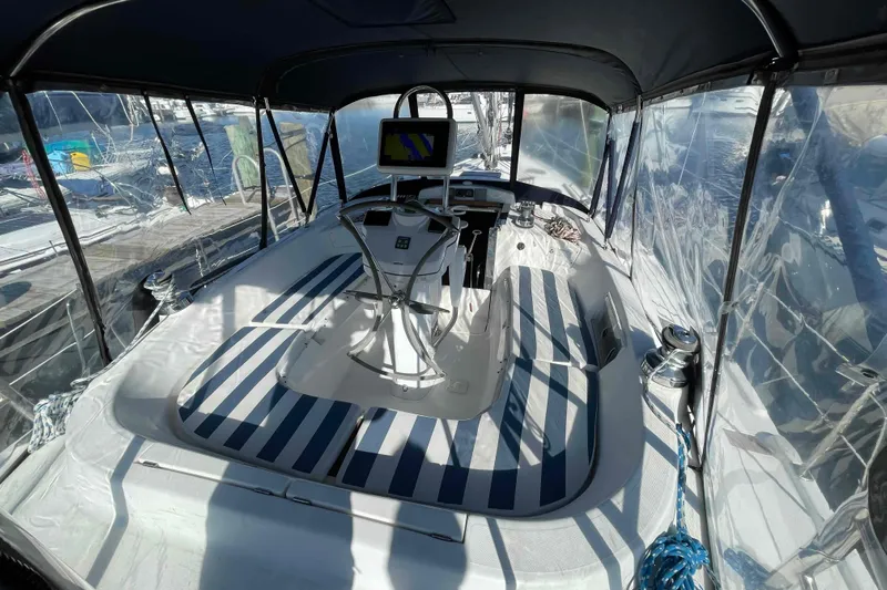 Snail'n Yacht Photos Pics 2010 Hunter 45 Center Cockpit sailboat interior with striped seating and navigation equipment.