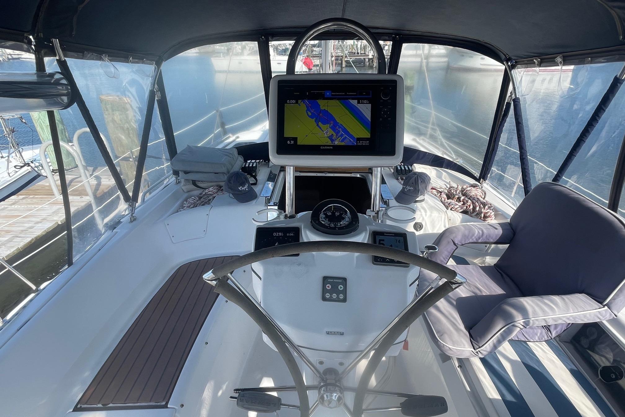 2010 Hunter 45 Center Cockpit with navigation system and comfortable seating in a marina setting.