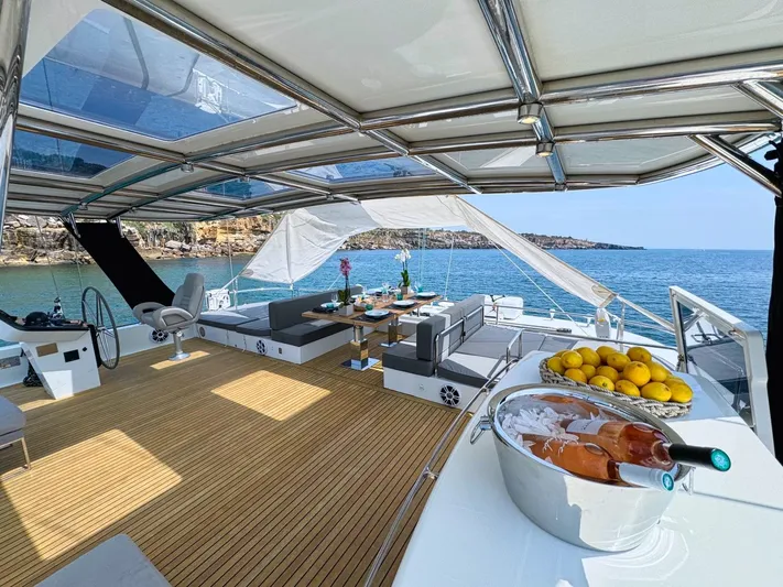 Feel The Blue Yacht Photos Pics Luxurious Sunreef 60 yacht deck with seating, dining area, and ocean view, 2018 model.