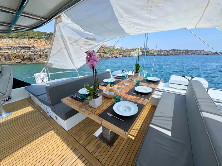 Feel The Blue Yacht Photos Pics Luxurious Sunreef 60 yacht deck with elegant dining setup, overlooking serene ocean view.