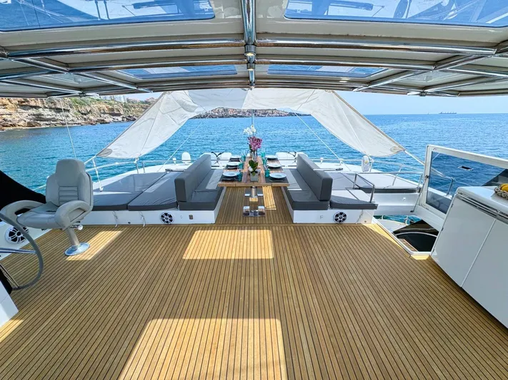 Feel The Blue Yacht Photos Pics Luxurious Sunreef 60 yacht deck with seating, ocean view, and elegant decor, 2018 model.