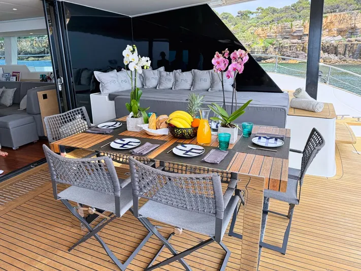 Feel The Blue Yacht Photos Pics Luxurious Sunreef 60 yacht deck with elegant dining setup, orchids, and ocean view, 2018 model.