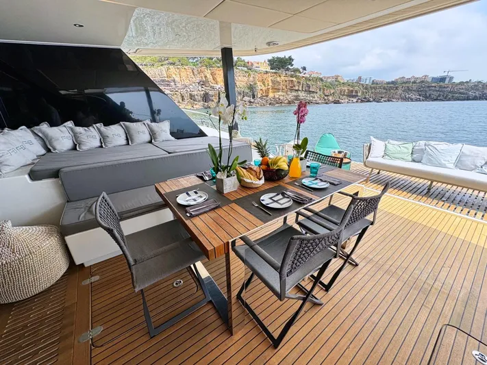 Feel The Blue Yacht Photos Pics Luxurious Sunreef 60 yacht deck with dining area, 2018 model, overlooking scenic coastal view.