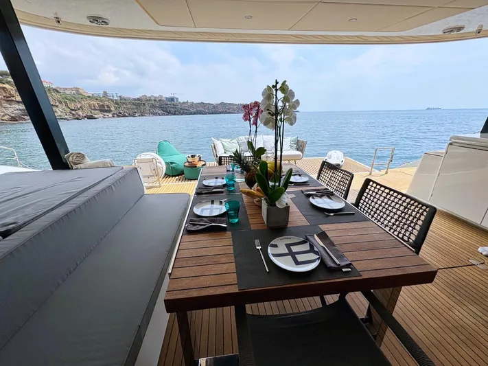 Feel The Blue Yacht Photos Pics Luxurious Sunreef 60 yacht deck with dining setup, overlooking serene ocean view, 2018 model.
