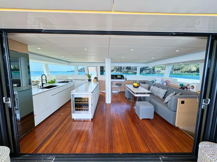 Feel The Blue Yacht Photos Pics Luxurious interior of 2018 Sunreef 60 yacht with modern kitchen and spacious seating area.