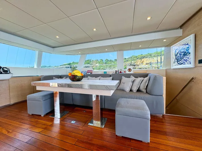 Feel The Blue Yacht Photos Pics Luxurious Sunreef 60 yacht interior with modern seating, wooden flooring, and scenic views.