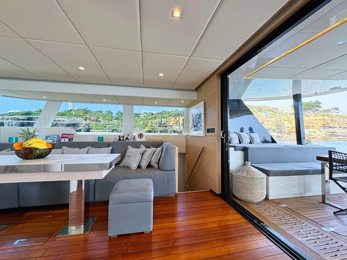 Feel The Blue Yacht Photos Pics Luxurious interior of 2018 Sunreef 60 yacht with modern seating and wooden flooring.