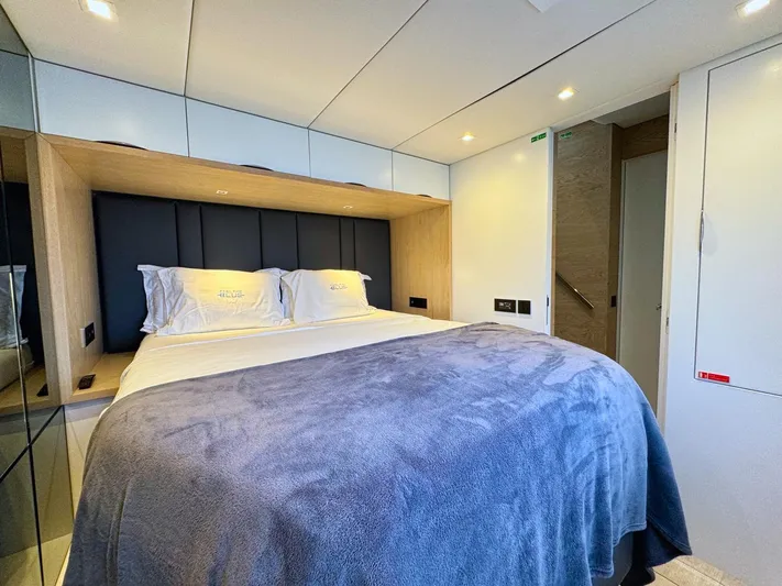 Feel The Blue Yacht Photos Pics Luxurious Sunreef 60 yacht bedroom interior, featuring a cozy bed with modern design elements, 2018 model.